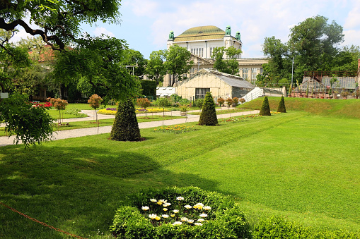 Lush plants in botanical garden, in Zagreb, Croatia. Historical archive building in the background.