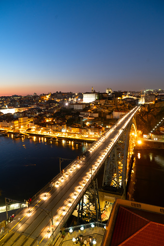 Picturesque, colorful view at old town Porto with famous bridge at night, Portugal with bridge Ponte Dom Luis over Douro river. Oporto, touristic mediterranean city