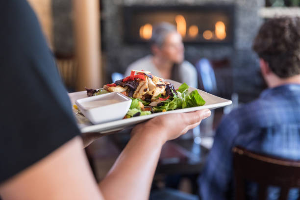 istock Unrecognizeable restaurant worker delivers a delicious salad to the table 1470804750