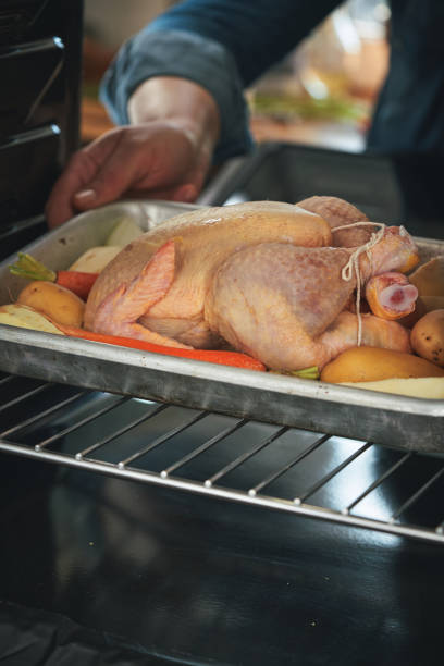 istock Preparing Roasted Chicken with Root Vegetables in Domestic Kitchen 1470805145