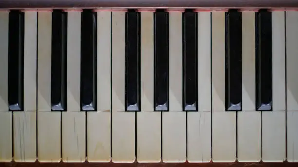 Photo of Antique piano keyboard with cracked and yellowed ivory keys