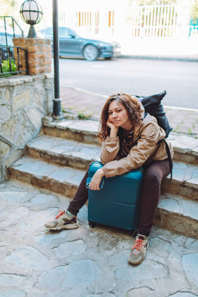istock Young woman with suitcase  getting lost and searching hotel 1470806781