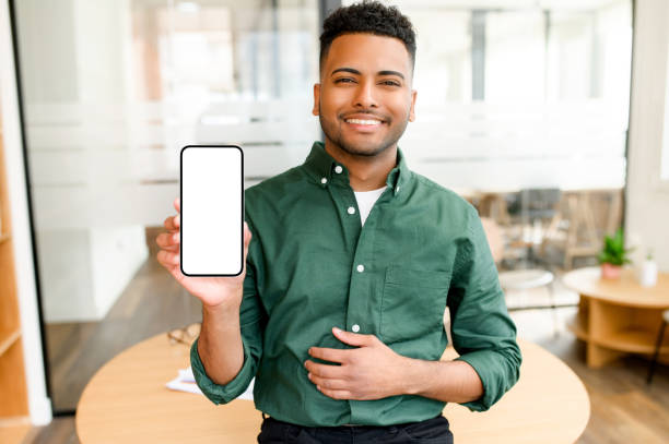 istock Handsome Indian man holding and showing smartphone with empty phone screen, confident businessman presenting best deal 1470808073