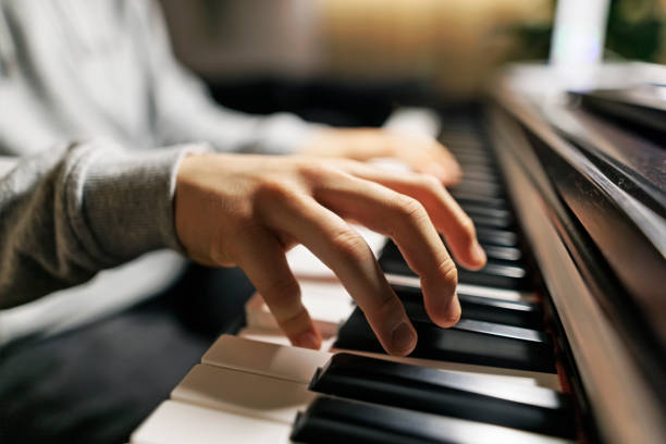 Teenage boy practicing piano at home