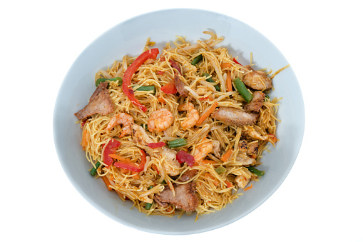 Bowl of Singapore noodles with chopsticks viewed from above - white background