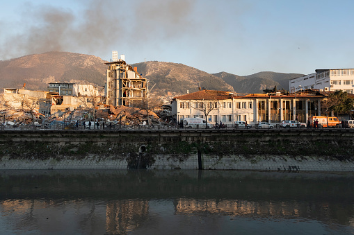Hatay, Turkey February 8, 2023\n  Many buildings were destroyed due to the earthquake. The condition of the remaining buildings is poor. Smoke rises in the background. People are in fear. They wander helplessly in the street. Rescue work continues.