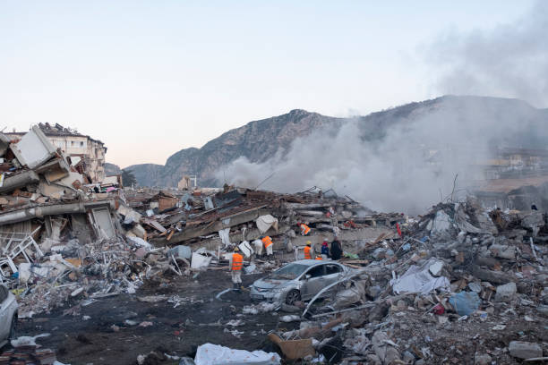 smoke billows from dilapidated buildings. - antakya imagens e fotografias de stock