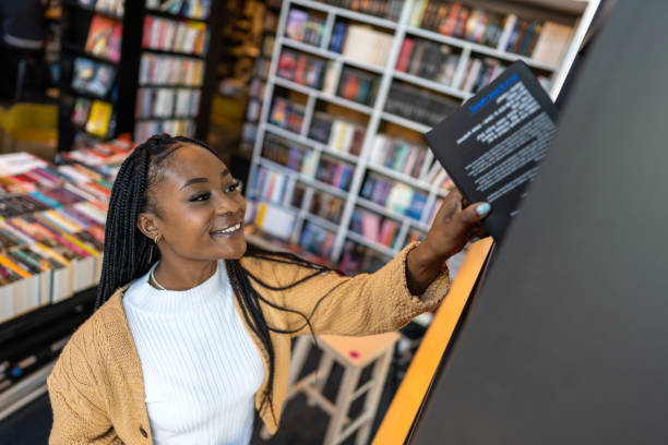 Young librarian picking book from bookshelf Young librarian picking book from bookshelf bookstore stock pictures, royalty-free photos & images