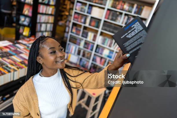 Young Librarian Picking Book From Bookshelf Stock Photo - Download Image Now - Bookshelf, Choosing, Book