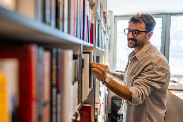 istock Mid adult man working and reading in his library 1470815022