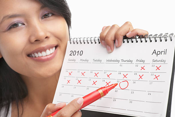 Woman with red felt tip pen and calendar, actually can be concept to get pregnant from its series, maybe can be used for US tax day