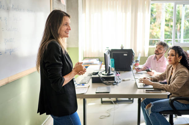 istock Smiling language teacher talking with adult students in a class 1470816103