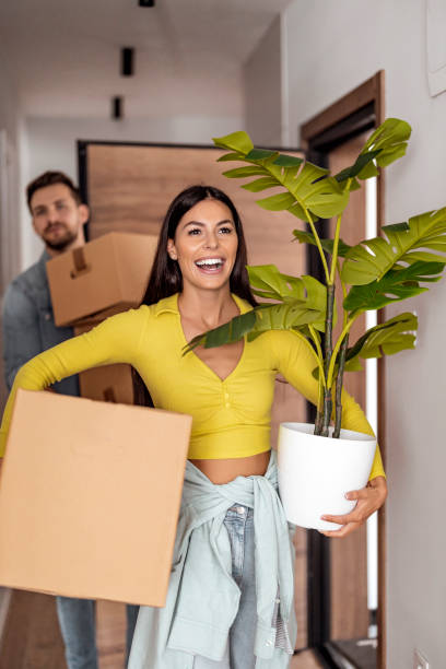 young couple moving to a new apartment - moving house apartment couple box imagens e fotografias de stock