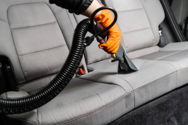 istock Car dry cleaner is using extraction machine for removing stains and dirt from textile seats. Close-up dry cleaning extractor machine is spraying water and detergent on textile seat inside car. 1470818528
