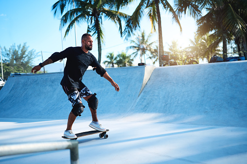 portrait brazilian mature man with leg impairment skateboarding in a skate park
