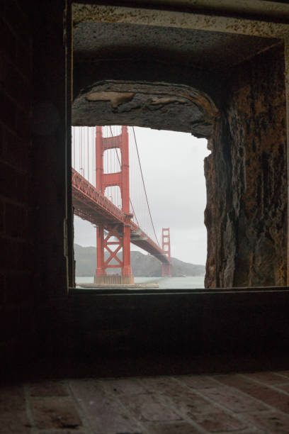 image sombre spectaculaire prise à l’intérieur du site historique de fort point, à san francisco, en californie, donnant sur le golden gate bridge. - fort point historic site photos et images de collection