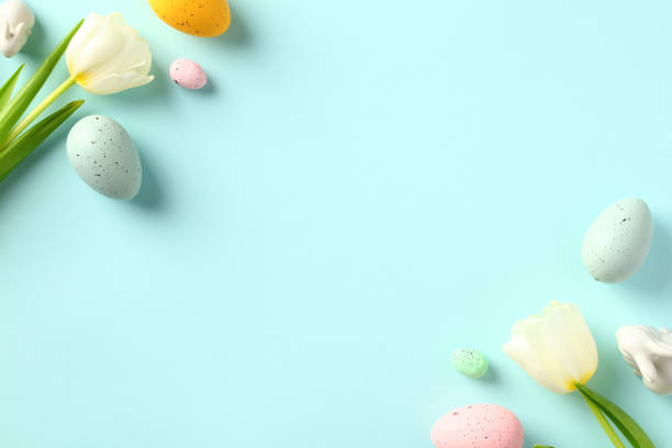 istock Happy Easter greeting card template. Easter banner design with colorful eggs and white tulips on pastel blue table. Flat lay, top view. 1470824193