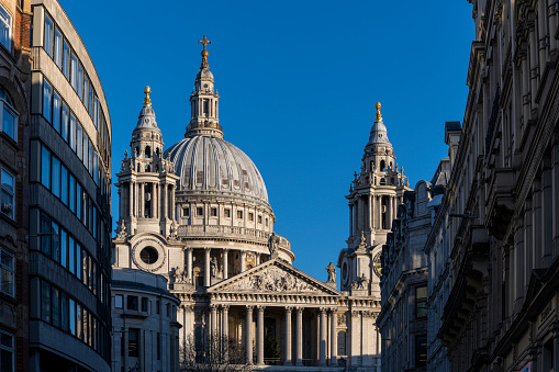 St. Paul's Cathedral in London between buildings, UK. This is Christopher Wren's masterpiece and one of London's top tourist attractions.