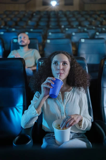 Woman in movie theater alone watching movie stock photo