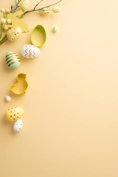 istock Easter mood concept. Top view vertical photo of colorful easter eggs baking molds and easter plant on isolated pastel beige background with copyspace 1470829488