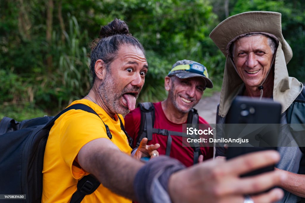 Best friends have a day of adventure A group of active senior male friends preparing for hiking in the wilderness Camping Stock Photo