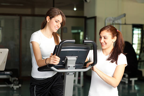 Happy young women in the gym biking stock photo