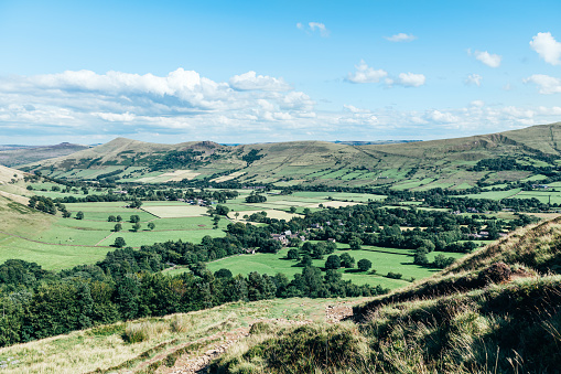 A stunning series of 6 images of English farmland in the Vale of Evesham at the northern extreme edge of the Cotswolds in the English Midlands. The shoot was made in mid-October 2019 in late afternoon autumn sunlights and the muted colours of browns, golds and greens under expansive blue skies with dappled cloudscapes perfectly compliment each other. The patchwork of ploughed or harrowed fields, hedgerows and mature deciduous trees are archetypal English Pastoral scenes of the kind so popular with 18th Century artists like Constable and these atmospheric images evoke the same timeless qualities as those paintings. This fourth picture in the series is a telephoto image of the patchwork andscape of fileds in the far distance. The compressed focal length and the criss-crossing of the hedgerows and trees above the bright green or brown ploughed fields emphasises the pastoral nature of this iconic landscape.