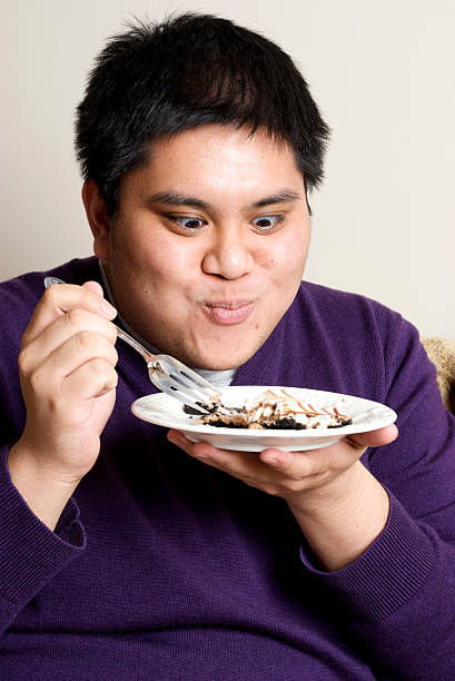 Grande uomo asiatico degistando Dessert - foto stock