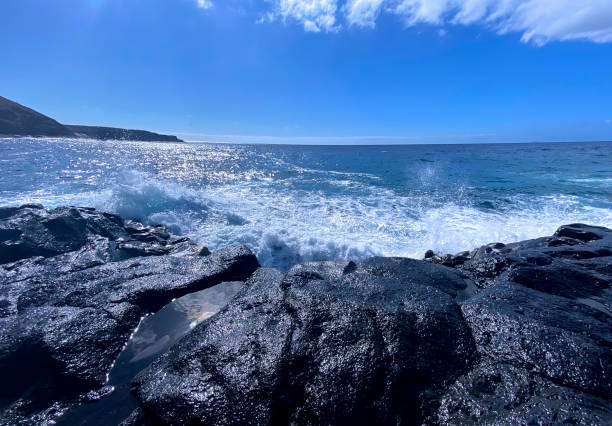 Waves and white foam breaks a rocky coastline Landscape and wild scenery from the Canary Islands in the Atlantic Ocean rocky coastline stock pictures, royalty-free photos & images