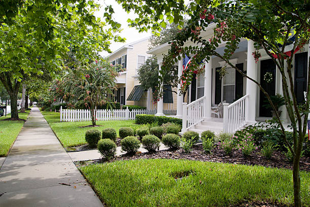 Suburban street in Nazareth, Pennsylvania, on a sunny spring day featuring well-manicured lawns and traditional American homes. Vibrant green grass, sidewalks, and a variety of lush trees and shrubs line the walkway