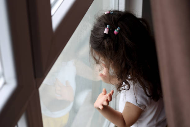 istock Little girl looking out the window 1470841899