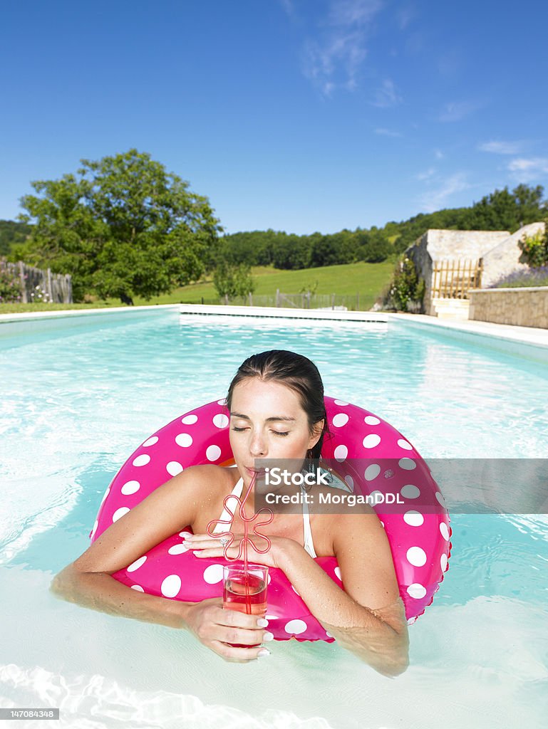 Mulher flutuando na piscina e desfrutar de bebidas - Foto de stock de 20 Anos royalty-free