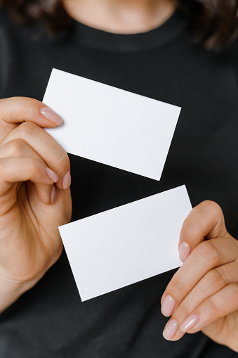 Woman's hands holding white business cards