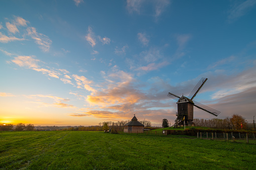 Early in the morning there is a beautiful windmill whit the sun rising in the sky