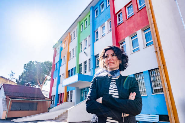 istock Young teacher standing infront of school building 1470851419