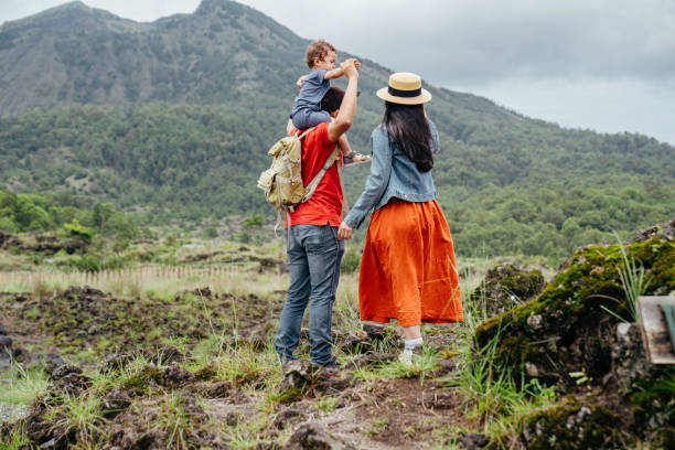 coppie asiatiche che trasportano il suo bambino che guarda il monte batur - rear view family isolated child foto e immagini stock