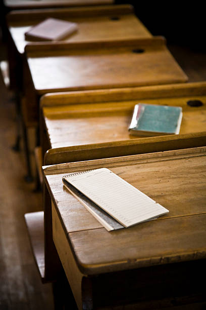 istock Old fashioned school desks with pads of paper 147086468