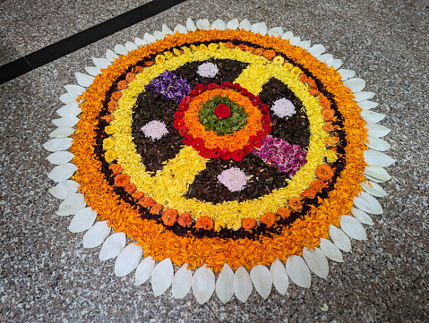 Beautiful Rangoli made by flower petals on Diwali festival and some of oil lamps burning on Diwali. Rangoli is an art form, originating in the Indian subcontinent, in which patterns are created on the floor or the ground using materials such as colored rice, dry flour, colored sand or flower petals.