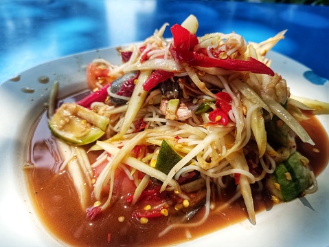 Papaya Salad with Crab, Pickled Fish, Papaya Salad, a local food of the Northeast of Thailand. Ingredients include papaya, pickled salted crab, tomatoes, chili, mix everything together and put it in a mortar. Spicy taste that everyone around the world knows.