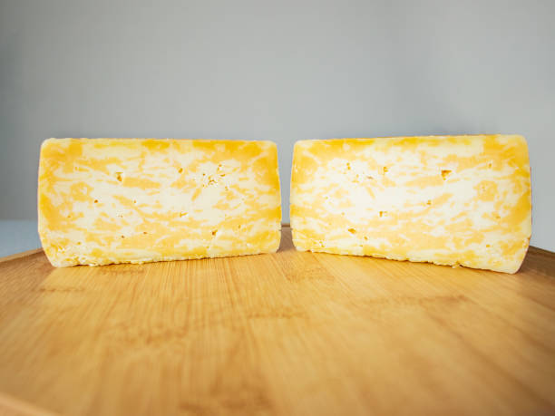 istock cut marble cheese head on a wooden cutting board, close up, hard cheese 1470865595