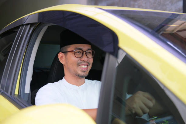 Moslem Asian man smiling happy when driving his car Moslem Asian man smiling happy when driving his car keluarga stock pictures, royalty-free photos & images