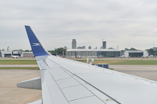 Buenos Aires, Argentina, November 18, 2022: Plane wing, view from a window of a Boeing 737-700 jet of Aerolineas Argentinas moving down the runway before takeoff, Jorge Newbery International Airport