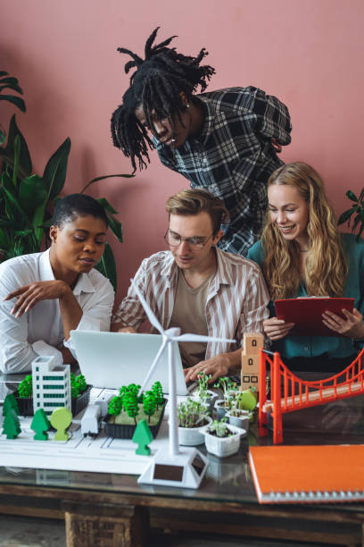 istock International diverse group of students working on modern urban architecture project with renewable green energy source, alternative electricity, waste recycling. Brainstorming ideas, business plan 1470867789