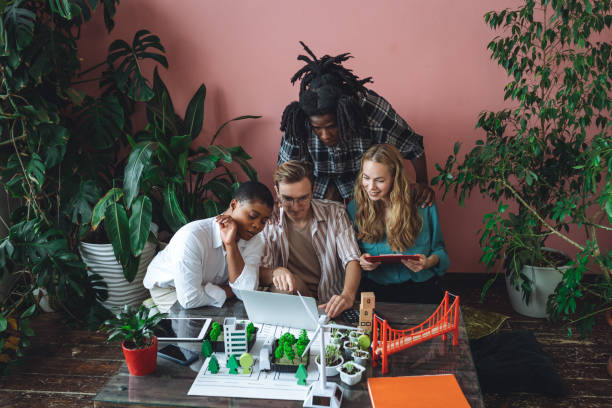 istock International diverse group of students working on modern urban architecture project with renewable green energy source, alternative electricity, waste recycling. Brainstorming ideas, business plan 1470867790