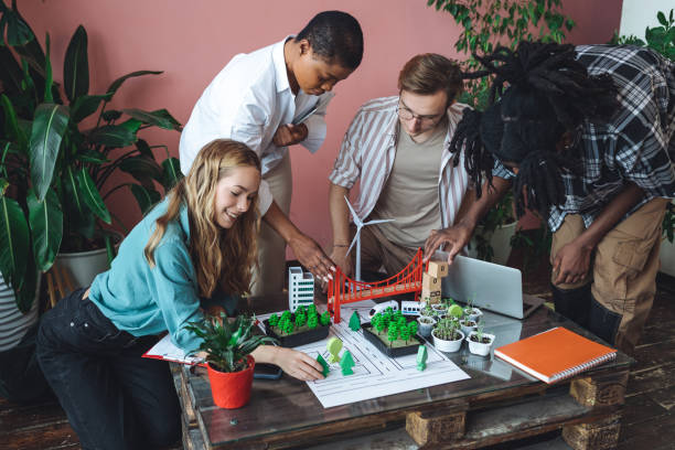 istock International diverse group of students working on modern urban architecture project with renewable green energy source, alternative electricity, waste recycling. Brainstorming ideas, business plan 1470868481