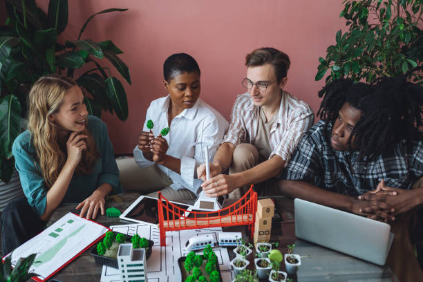 istock International diverse group of students working on modern urban architecture project with renewable green energy source, alternative electricity, waste recycling. Brainstorming ideas, business plan 1470868510