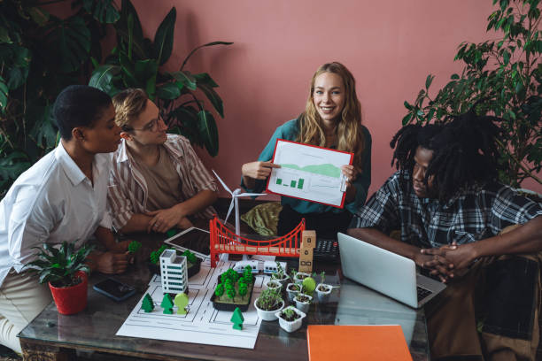 istock International diverse group of students working on modern urban architecture project with renewable green energy source, alternative electricity, waste recycling. Brainstorming ideas, business plan 1470868511