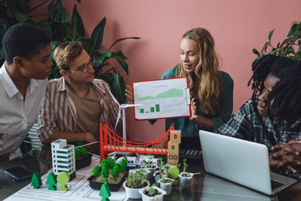 istock International diverse group of students working on modern urban architecture project with renewable green energy source, alternative electricity, waste recycling. Brainstorming ideas, business plan 1470868515