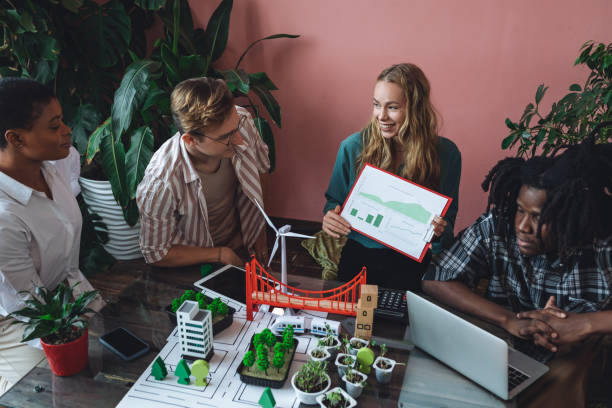 istock International diverse group of students working on modern urban architecture project with renewable green energy source, alternative electricity, waste recycling. Brainstorming ideas, business plan 1470868528