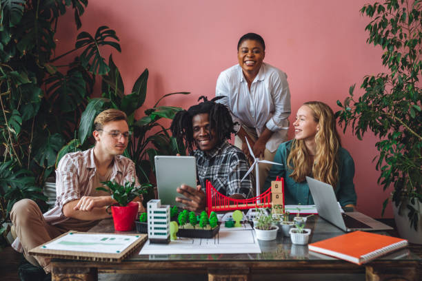 istock International diverse group of students working on modern urban architecture project with renewable green energy source, alternative electricity, waste recycling. Brainstorming ideas, business plan 1470868631